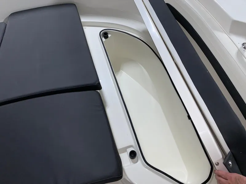Slide: The Image of Bayliner Trophy 24 CC 2024 storage compartment with black cushioned seating. - 13