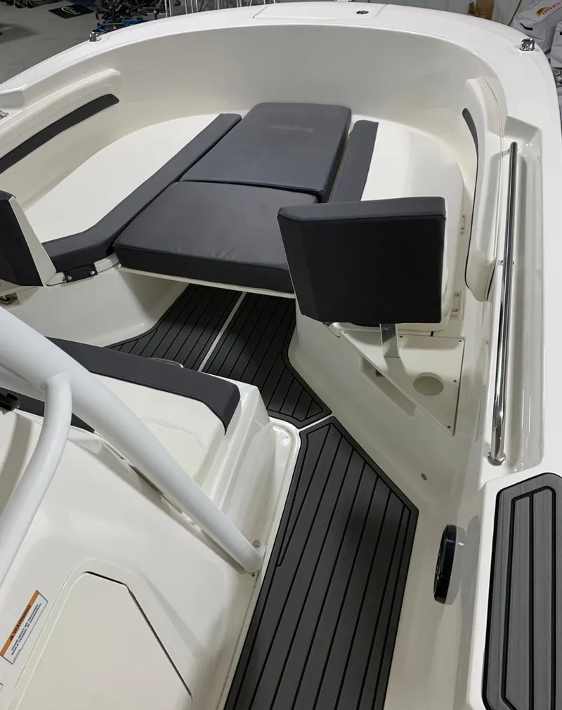 Slide: The Image of 2024 Bayliner Trophy 24 CC boat interior with cushioned seating and non-slip flooring. - 7