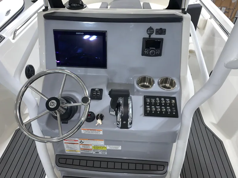 Slide: The Image of 2024 Bayliner Trophy 24 CC helm with steering wheel, controls, and electronic display. - 4