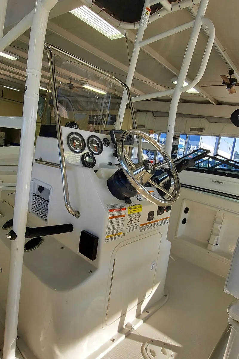 Slide: The Image of 2023 Bayliner Trophy T21Bay boat console with steering wheel and gauges in a showroom. - 8