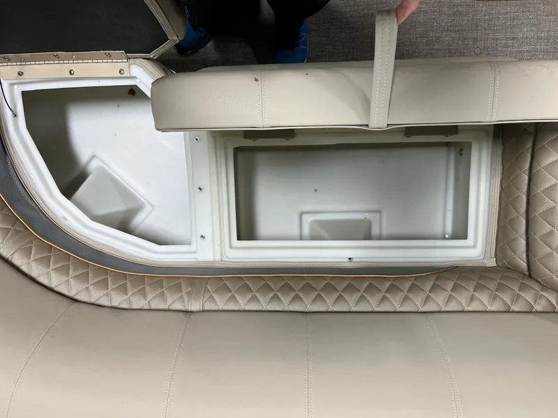 Slide: The Image of 2023 Ranger Reata 223C boat storage compartment with beige cushioned seating. - 10