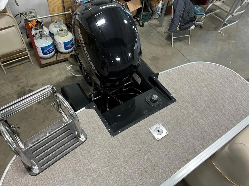 Slide: The Image of 2023 Ranger Reata 223C boat with Mercury outboard motor in a garage. - 14