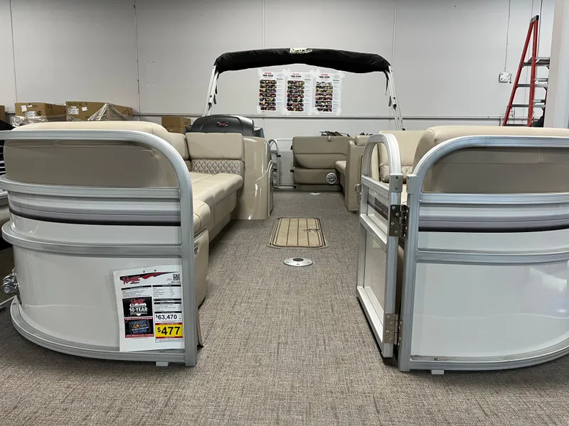 Slide: The Image of 2023 Ranger Reata 223C pontoon boat interior with beige seating and open gate. - 2