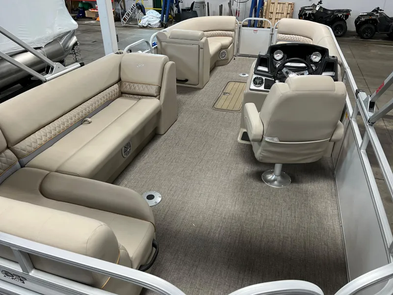 Slide: The Image of 2023 Ranger Reata 223C pontoon boat with beige seating and modern dashboard. - 9
