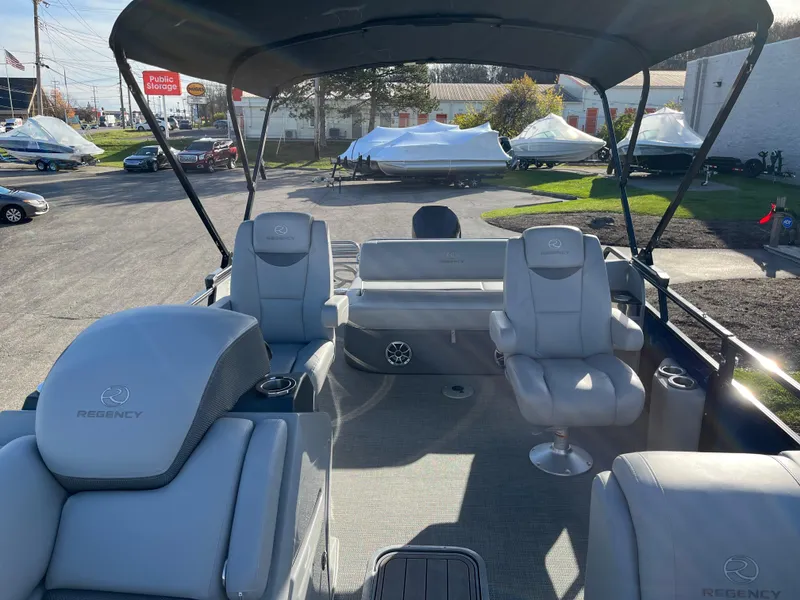 Slide: The Image of 2023 Regency 230 LE3 Sport pontoon boat interior with seating and canopy. - 1