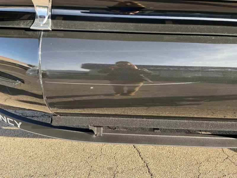 Slide: The Image of Close-up of a 2023 Regency 230 LE3 Sport boat with a scratch on the side. - 11