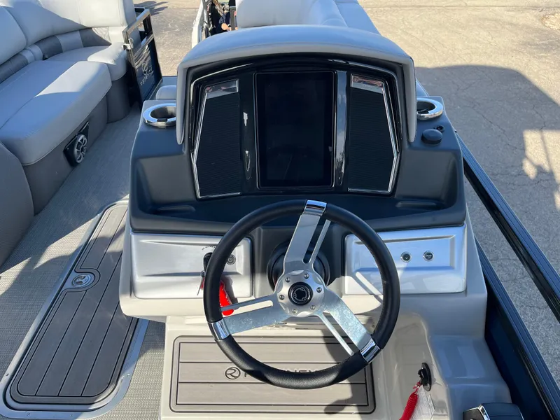 Slide: The Image of 2023 Regency 230 LE3 Sport boat helm with steering wheel and dashboard. - 2