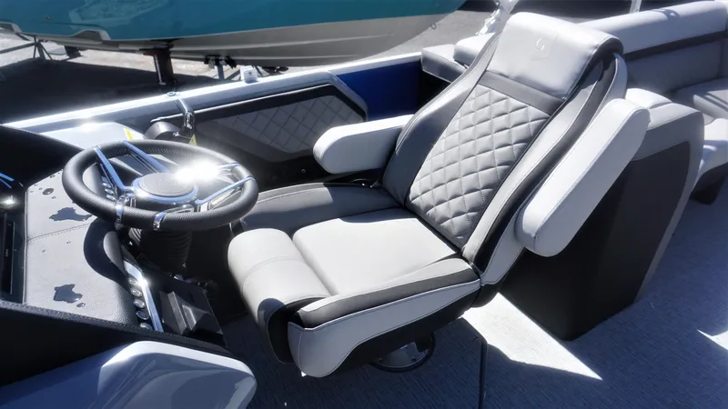 Slide: The Image of 2023 AquaPatio 235 ULC boat captain's chair and steering wheel, luxury interior. - 13