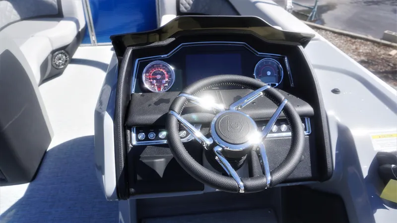 Slide: The Image of 2023 AquaPatio 235 ULC boat dashboard with steering wheel and instrument panel. - 15