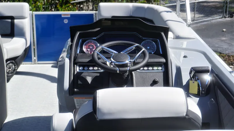 Slide: The Image of 2023 AquaPatio 235 ULC boat dashboard with steering wheel and controls. - 16
