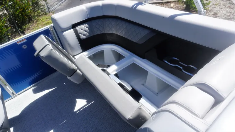 Slide: The Image of 2023 AquaPatio 235 ULC boat interior with gray cushioned seating and storage compartments. - 17
