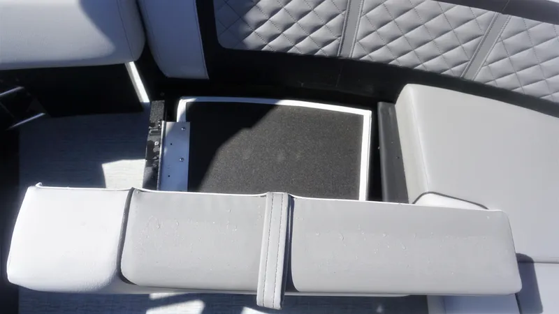 Slide: The Image of 2023 AquaPatio 235 ULC boat interior with gray cushioned seating and storage compartment. - 18