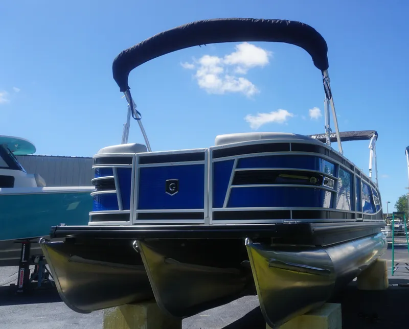 Slide: The Image of 2023 AquaPatio 235 ULC pontoon boat with blue exterior and black canopy. - 2