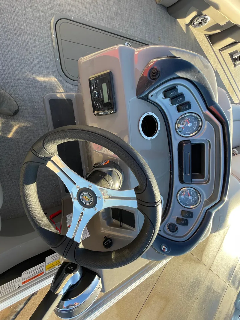 Slide: The Image of 2023 Sun Tracker SportFish 22 XP3 dashboard with steering wheel and controls. - 4