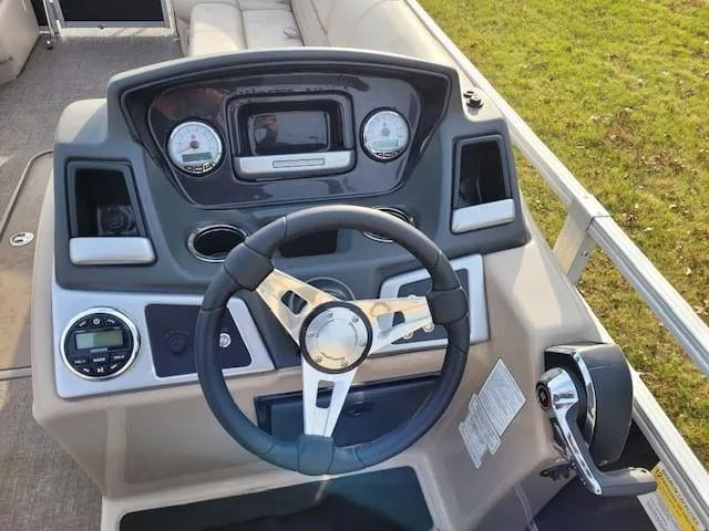 Slide: The Image of 2023 Ranger Reata 243C boat dashboard with steering wheel and control panel. - 3