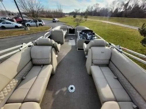 Slide: The Image of 2023 Ranger Reata 243C pontoon boat with spacious seating and modern dashboard. - 5