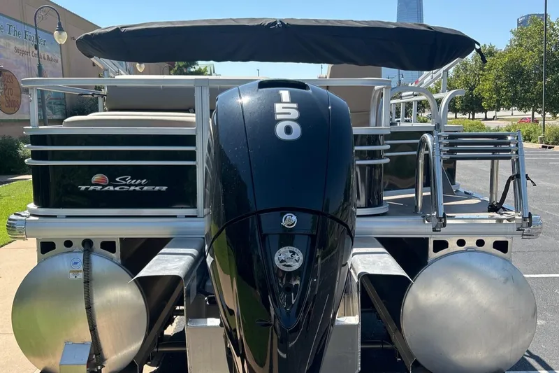 Slide: The Image of 2023 Sun Tracker SportFish 22 XP3 pontoon boat with 150 HP engine, docked outdoors. - 3