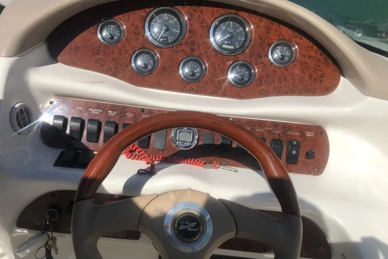 Slide: The Image of 2001 Sea Ray 280 boat dashboard with gauges and controls. - 2