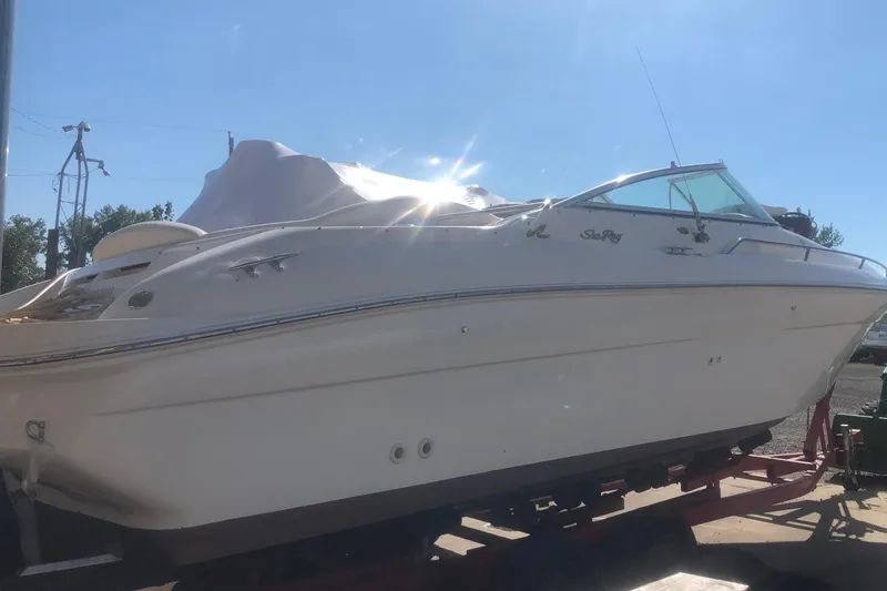 Slide: The Image of 2001 Sea Ray 280 boat on trailer under bright sunlight. - 23