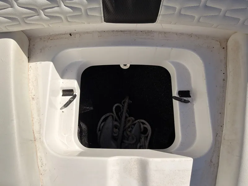 Slide: The Image of An open storage compartment on a boat with a rope inside. - 48