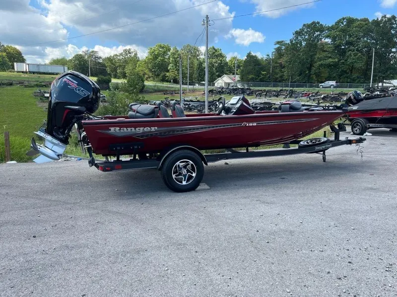 Slide: The Image of 2023 Ranger RT188 boat on trailer, red color, parked outdoors. - 1