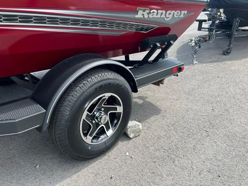 Slide: The Image of 2023 Ranger RT188 boat trailer with black wheel on pavement. - 3