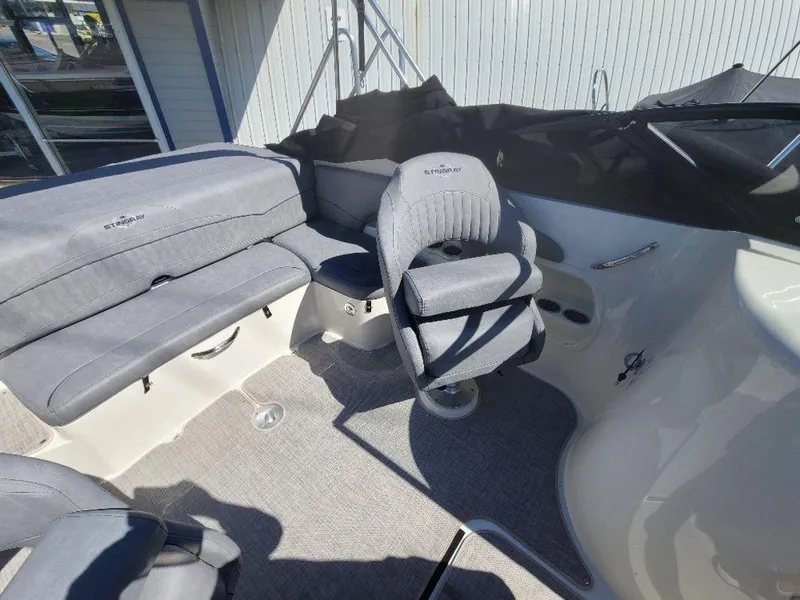 Slide: The Image of 2022 Stingray 215LR boat interior with gray seating and captain's chair. - 12