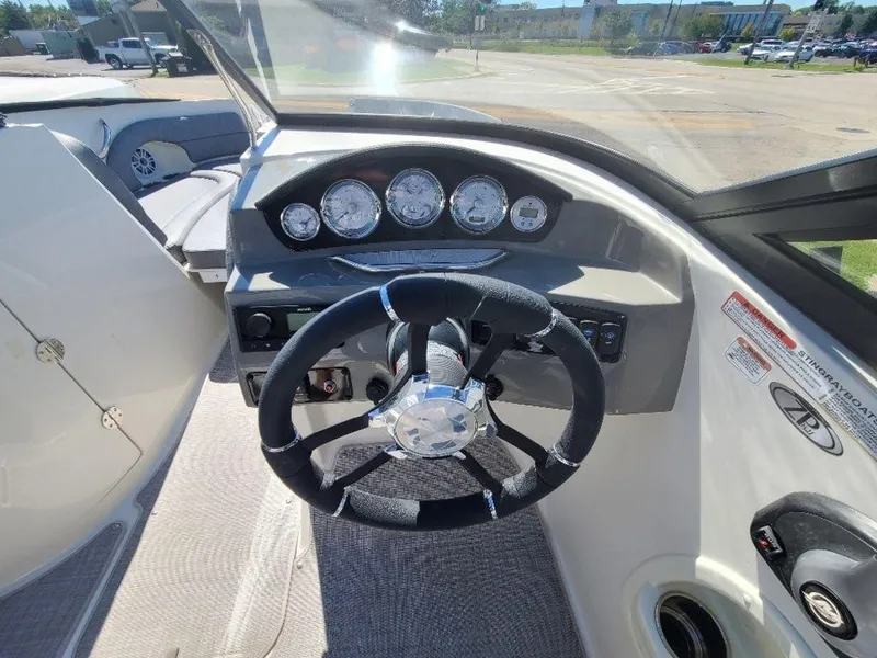 Slide: The Image of 2022 Stingray 215LR boat dashboard with steering wheel and instrument panel. - 13