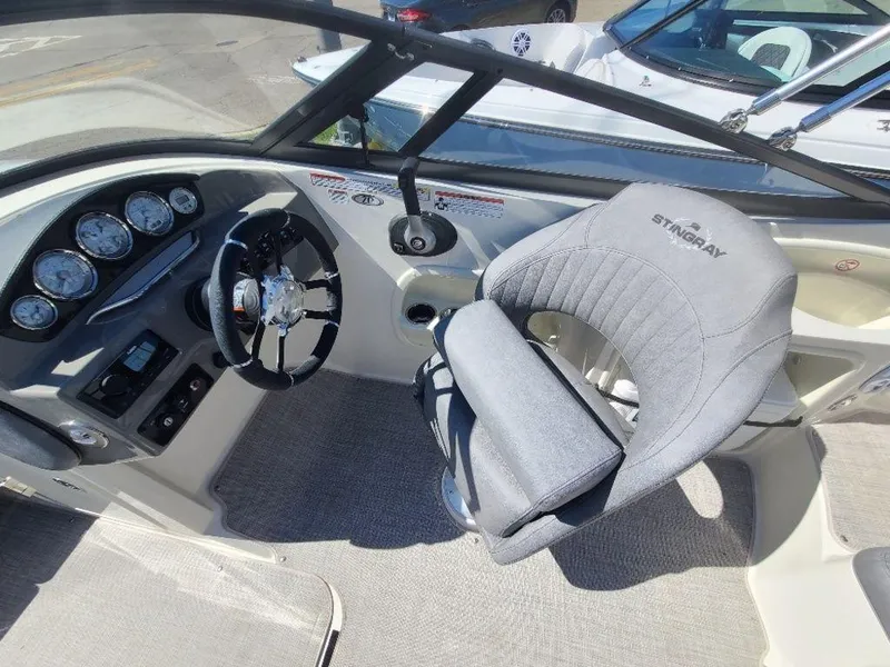 Slide: The Image of 2022 Stingray 215LR boat interior with steering wheel and captain's chair. - 14