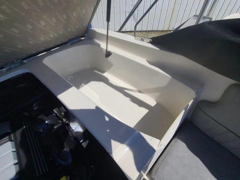 Slide: The Image of 2022 Stingray 215LR boat storage compartment with open lid. - 4