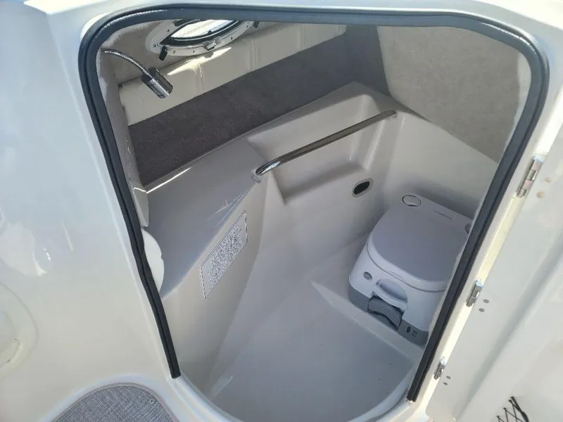 Slide: The Image of 2022 Stingray 215LR boat interior cabin with portable toilet. - 8