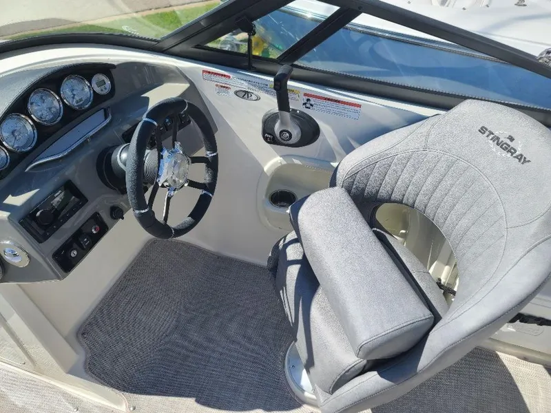 Slide: The Image of 2022 Stingray 215LR boat cockpit with steering wheel and captain's chair. - 9