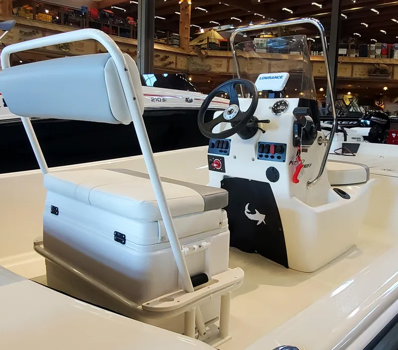 Slide: The Image of 2023 Mako Pro Skiff 17 CC center console boat interior with seating and steering wheel. - 2