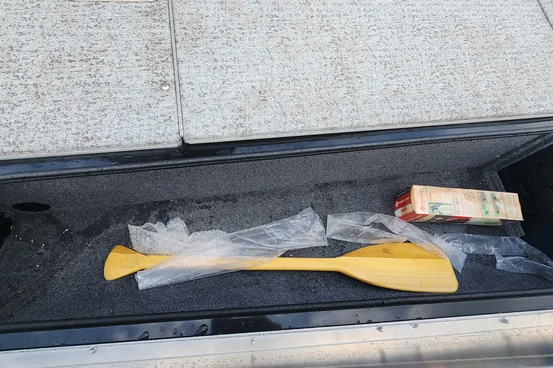Slide: The Image of Storage compartment of 2023 Tracker Pro Team 190 TX with paddle and carton. - 21