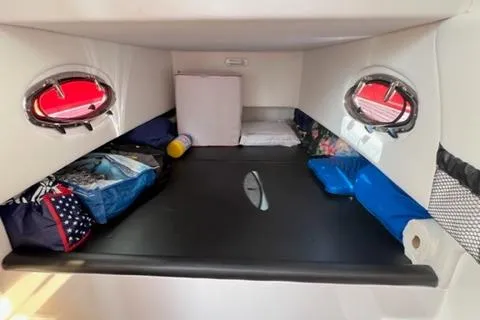 Slide: The Image of 2022 Nor-Tech 390 Sport Center Console cabin interior with storage and portholes. - 13