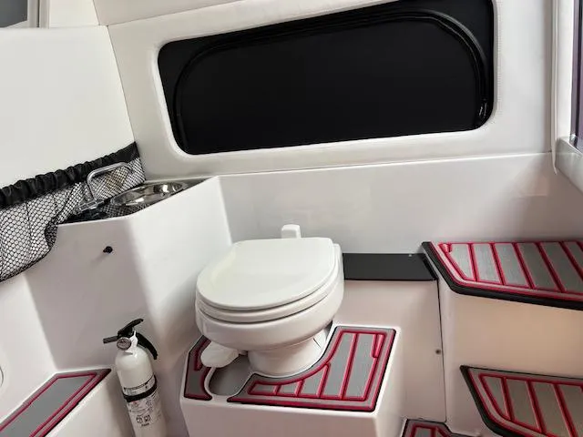 Slide: The Image of 2022 Nor-Tech 390 Sport Center Console boat interior with toilet and sink. - 14