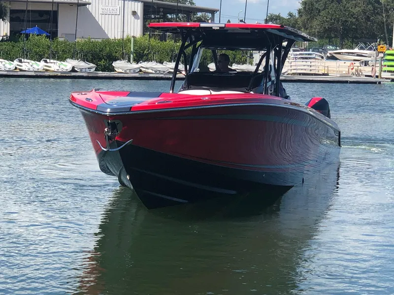 Slide: The Image of 2022 Nor-Tech 390 Sport Center Console boat on water near marina. - 2