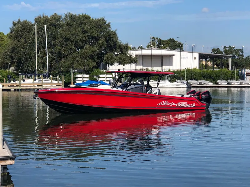 Slide: The Image of 2022 Nor-Tech 390 Sport Center Console boat in red on calm water. - 3