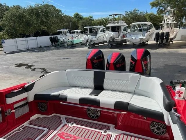 Slide: The Image of 2022 Nor-Tech 390 Sport Center Console boat with triple outboard engines and luxurious seating. - 6