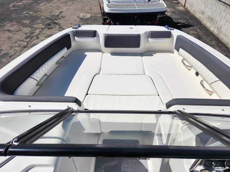 Slide: The Image of 2023 Bayliner DX2250 boat interior with white cushioned seating and windshield. - 13