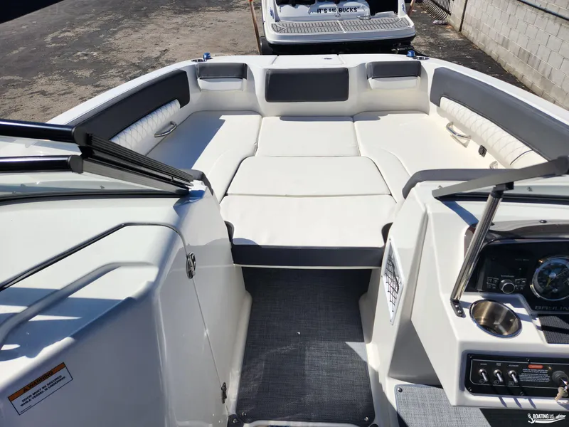 Slide: The Image of 2023 Bayliner DX2250 boat interior with spacious seating and modern dashboard. - 14