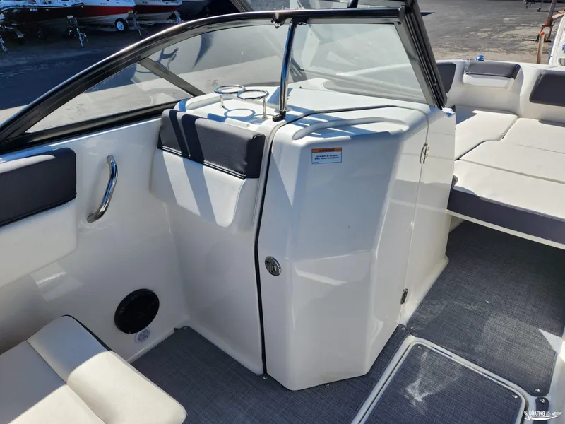 Slide: The Image of 2023 Bayliner DX2250 boat interior with seating and storage area. - 16