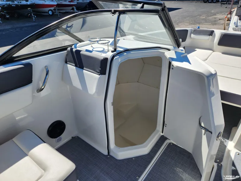 Slide: The Image of 2023 Bayliner DX2250 boat interior with open cabin door and seating area. - 17