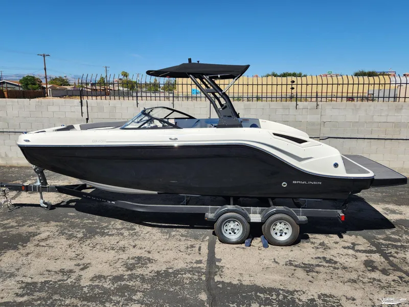 Slide: The Image of 2023 Bayliner DX2250 boat on trailer, black and white design, parked outdoors. - 2