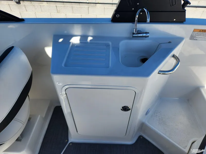Slide: The Image of 2023 Bayliner DX2250 boat interior with sink and storage cabinet. - 20