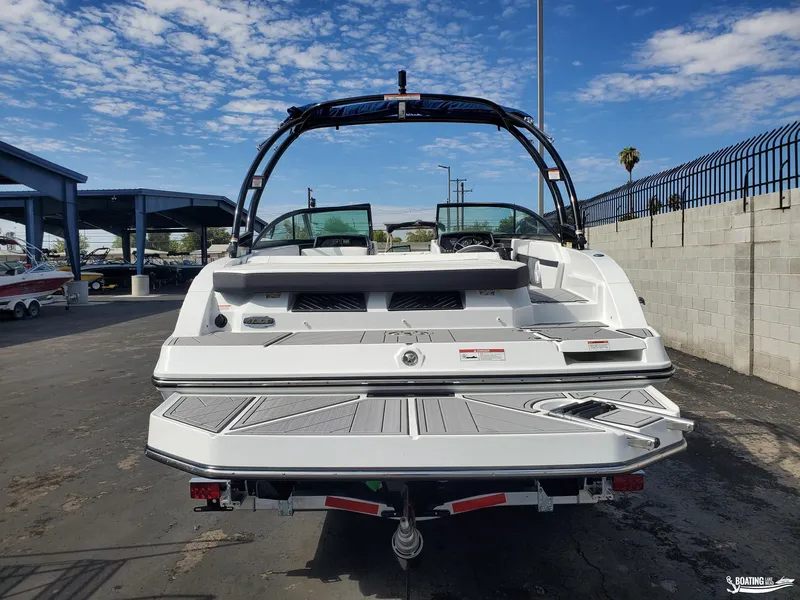Slide: The Image of 2023 Monterey M22 boat, rear view, parked outdoors under a blue sky. - 15