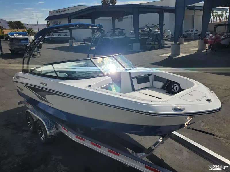 Slide: The Image of 2023 Monterey M22 boat on trailer at dealership, sunny day. - 18