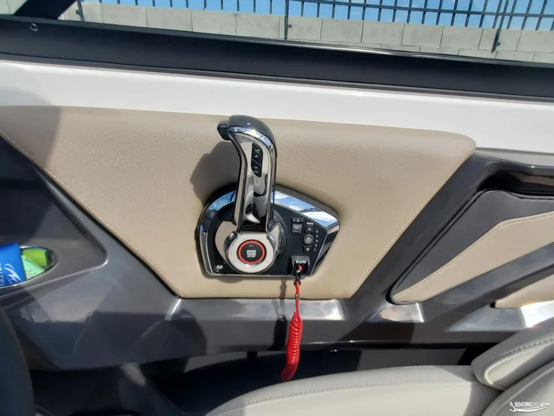 Slide: The Image of 2023 Monterey 238SS boat throttle control with start/stop button and beige interior. - 17