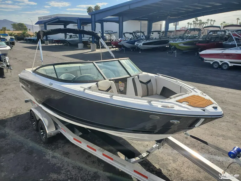 Slide: The Image of 2023 Monterey 238SS boat on trailer at dealership, surrounded by other boats. - 3