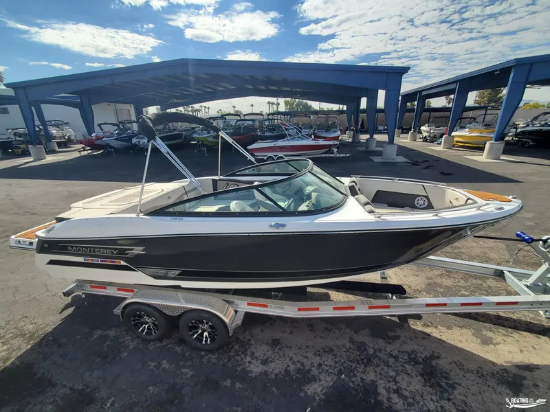 Slide: The Image of 2023 Monterey 238SS boat on trailer at dealership under blue sky. - 4